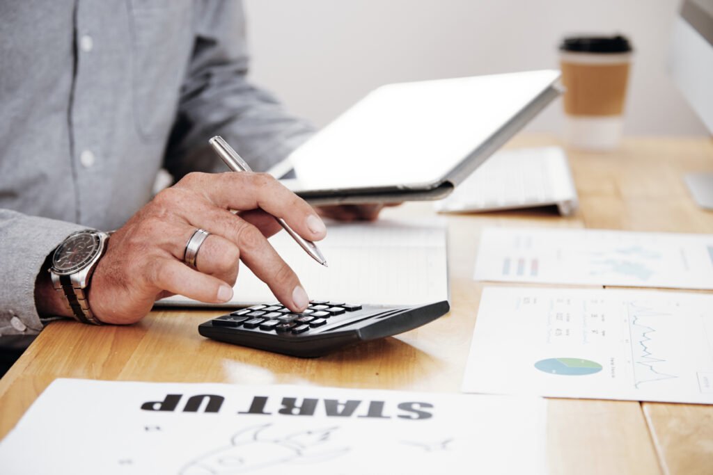 Business owner reviewing financial documents and planning taxes before selling a business, highlighting deal structure and after-tax proceeds.