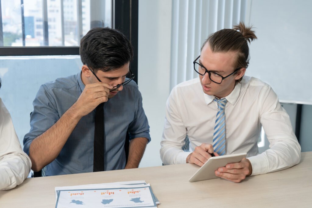 Business owner and potential buyer reviewing documents during a business sale discussion.
