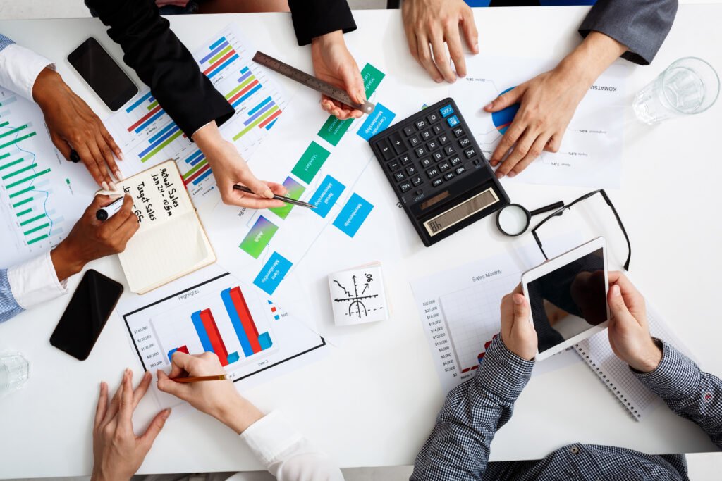 Businesspeople reviewing financial documents and charts at a table