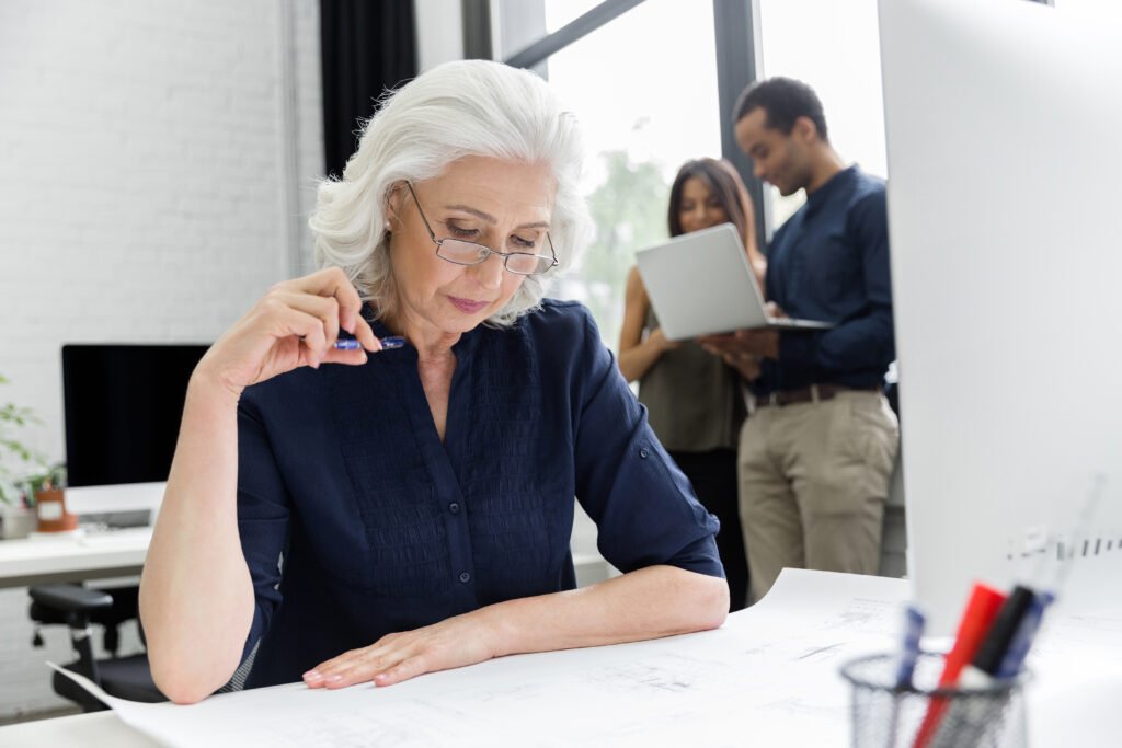 Senior business owner reviewing documents while planning a business exit.